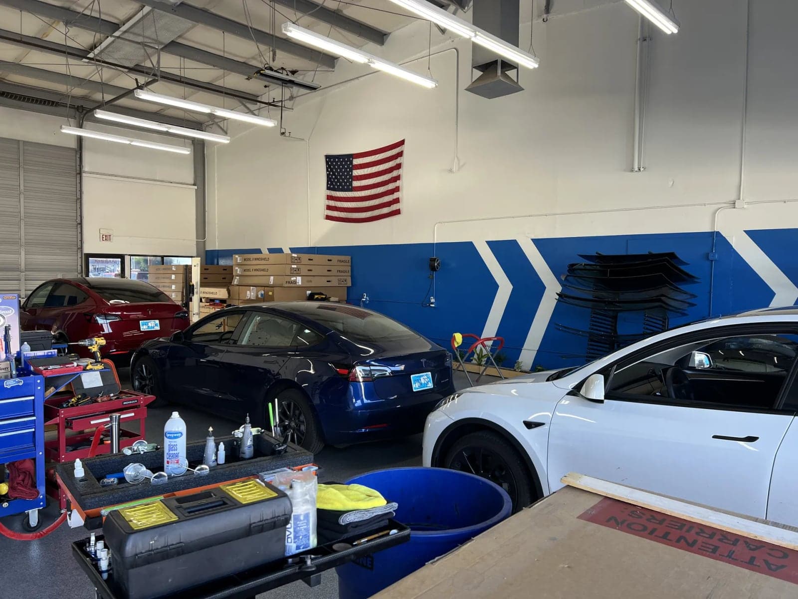 Teslas in front of the blue chevron wall in the Blue Chip shop